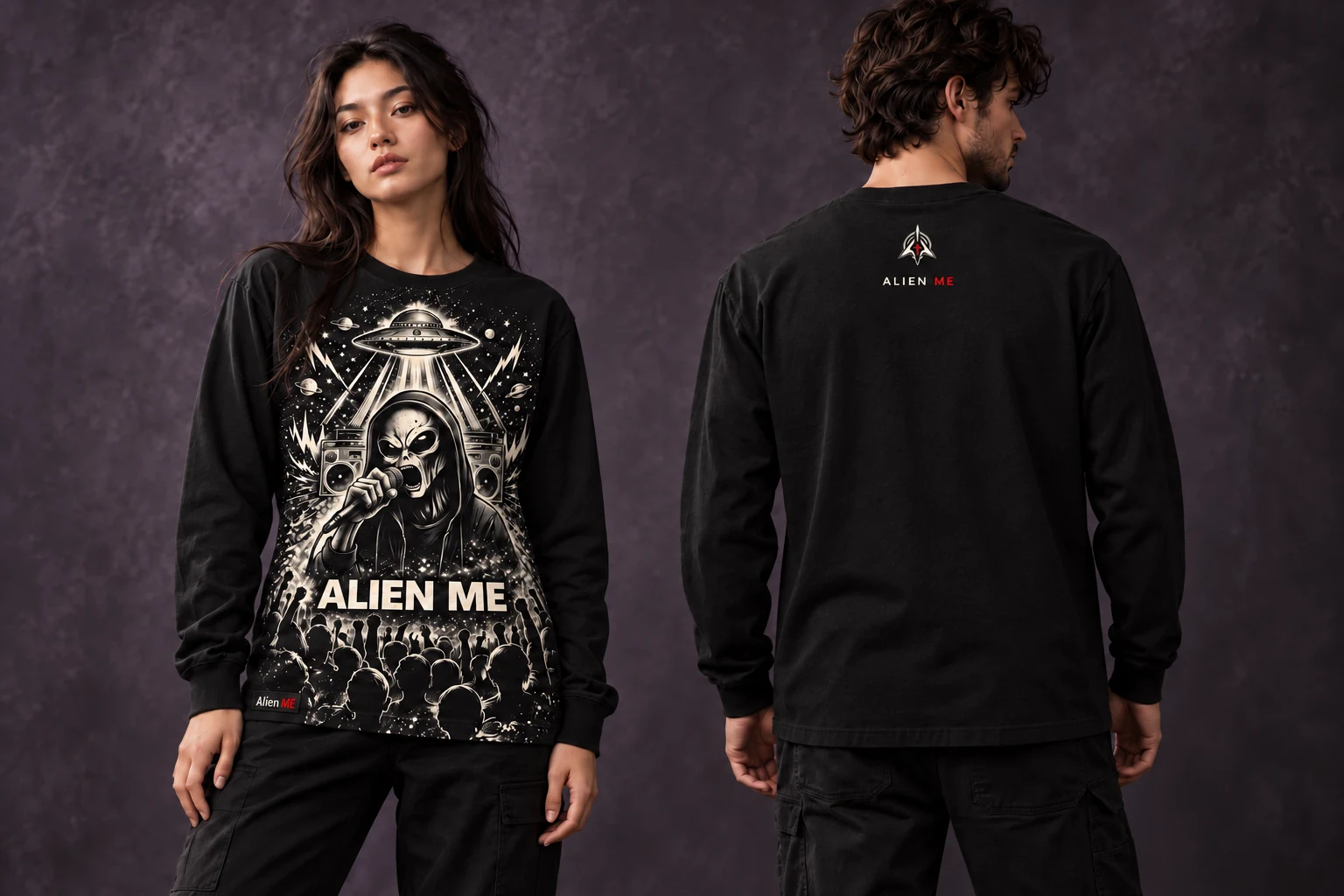 Two adult models wearing the black Performer Long Sleeve, showing the full-height performance illustration on the front down to the bottom hem, plain sleeves and a small upper-back AM mark